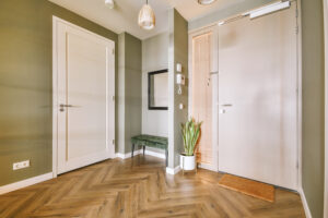 Corridor of contemporary apartment with opened doorway leading to living room